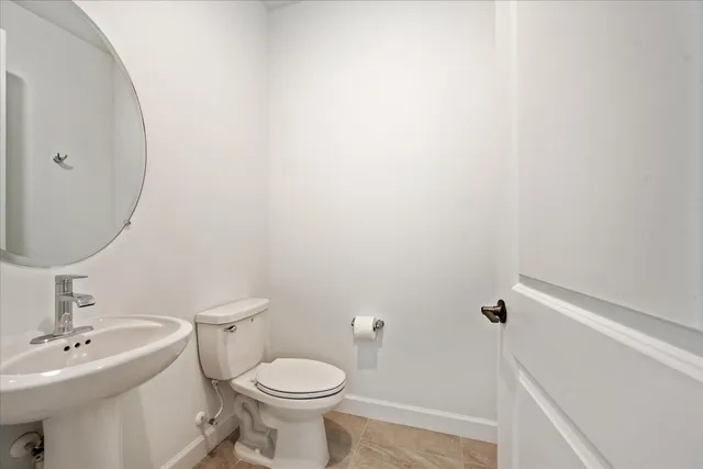 a white toilet sitting next to a bathroom sink