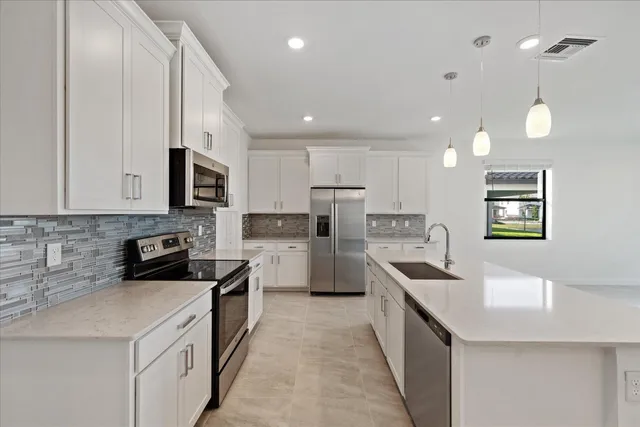 a kitchen with white cabinets and stainless steel appliances