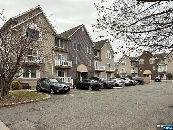 a view of a cars park in front of a brick house