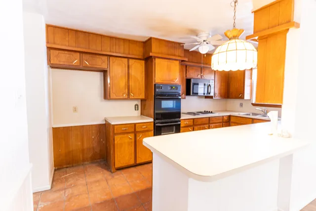 a kitchen with stainless steel appliances granite countertop a sink and a refrigerator