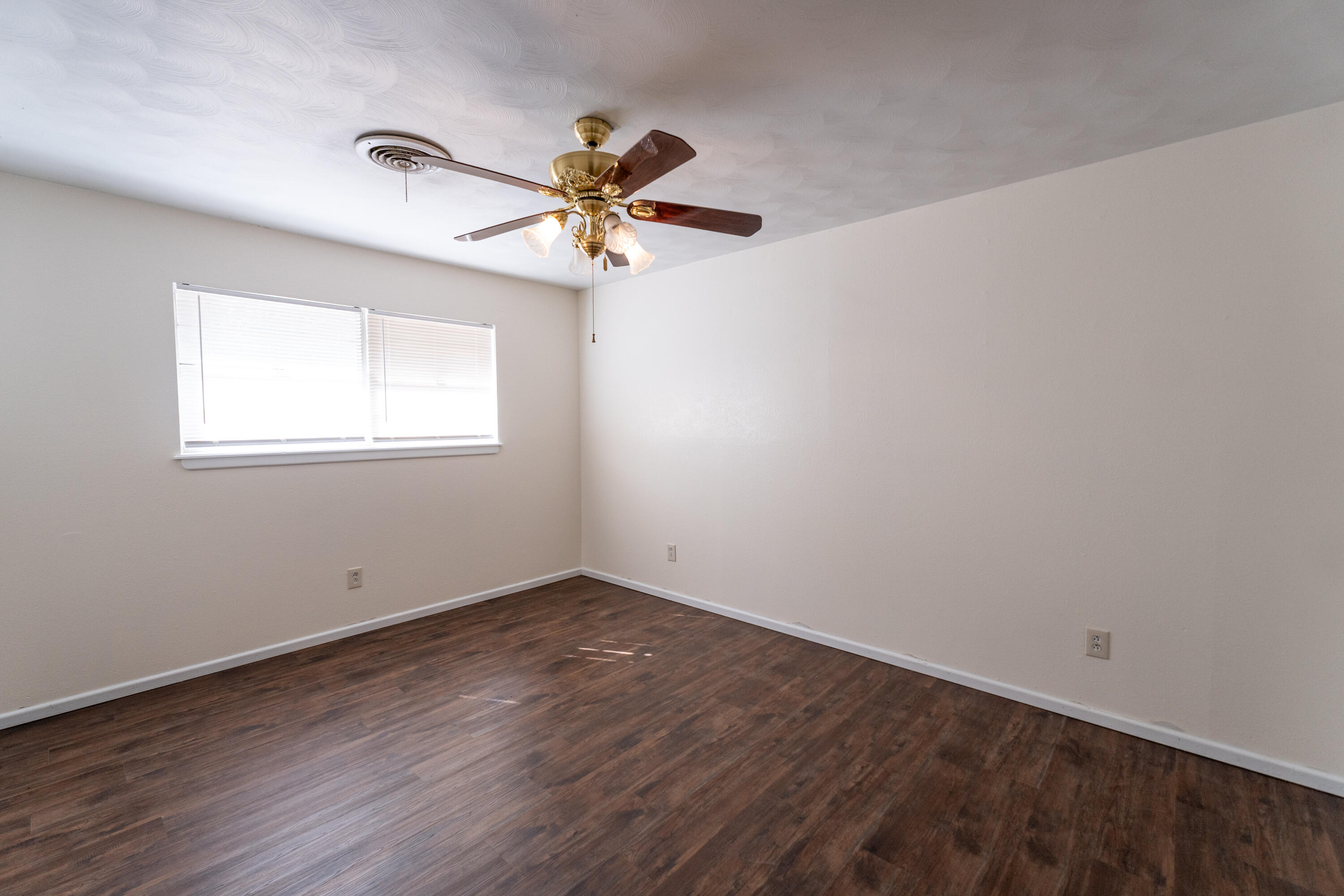 5314 46th Street Lubbock, TX 79414 - Photo 7 of 15 an empty room with wooden floor fan and windows