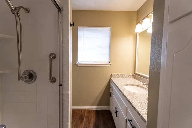 a bathroom with a granite countertop sink and a mirror