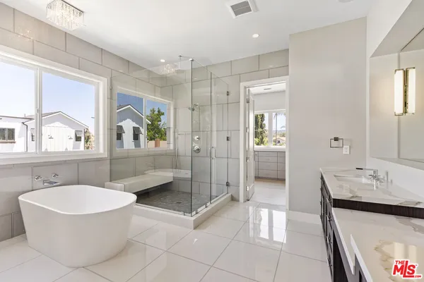 a bathroom with a bathtub shower sink and mirror