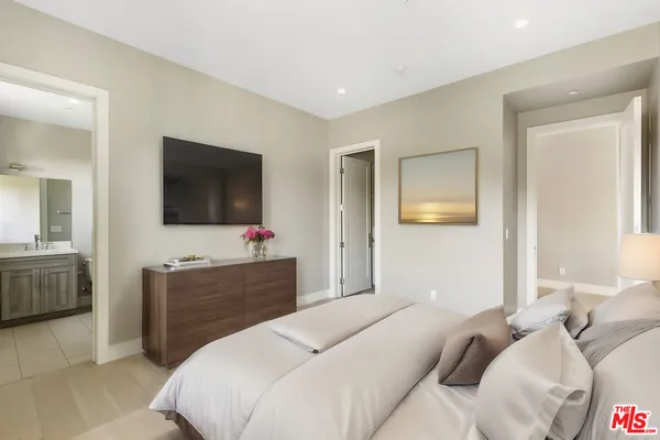a bedroom with a bed and a flat screen tv