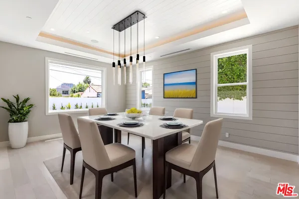 a view of a dining room with furniture a chandelier and wooden floor