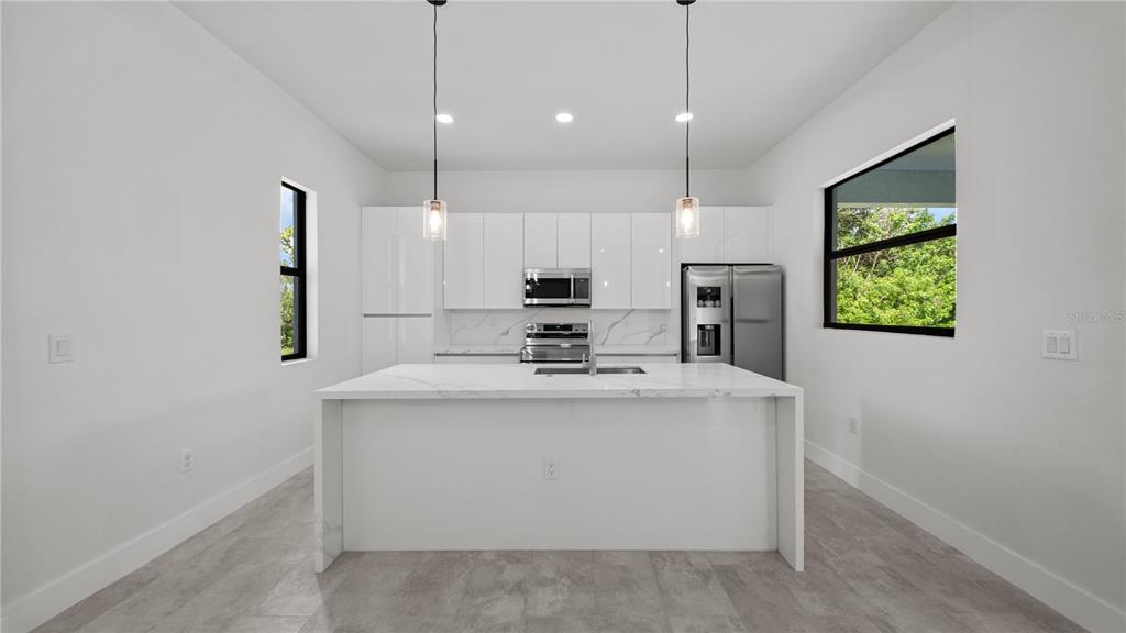 9 Tee View Road Rotonda West, FL 33947 - Photo 18 of 38 a view of kitchen with kitchen island stainless steel appliances a stove a sink and a chandelier