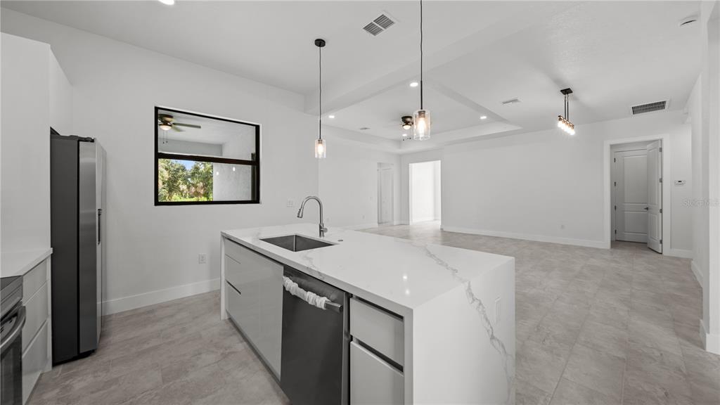 9 Tee View Road Rotonda West, FL 33947 - Photo 19 of 38 a kitchen with a sink a counter space and a refrigerator