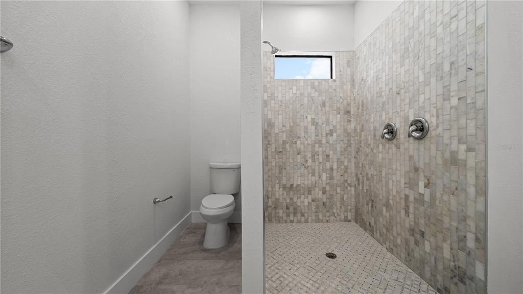 9 Tee View Road Rotonda West, FL 33947 - Photo 27 of 38 a bathroom with a granite countertop toilet and a shower