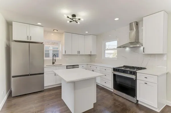 a kitchen with a stove a refrigerator and a sink