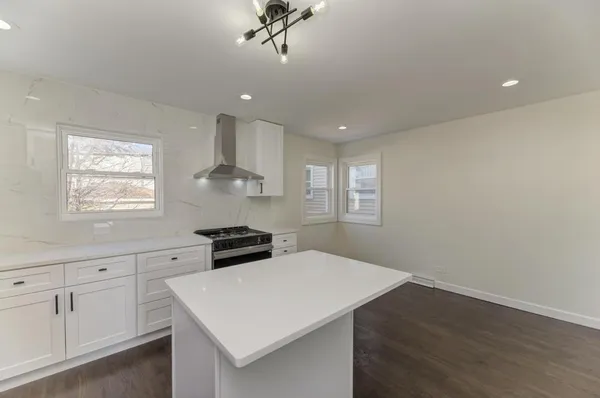 a kitchen with a white cabinets a sink dishwasher and a stove with wooden floor