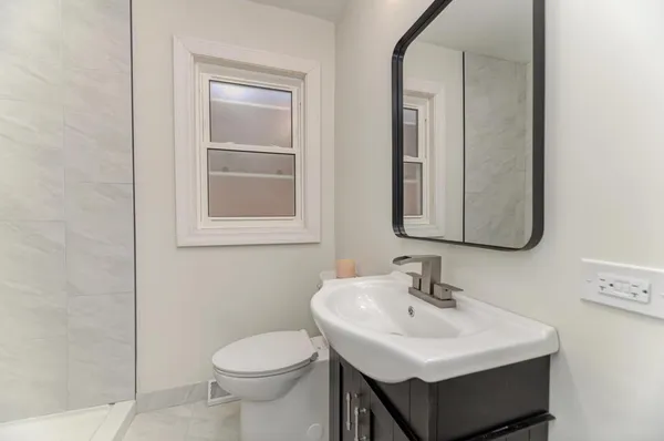 a bathroom with a sink toilet and mirror