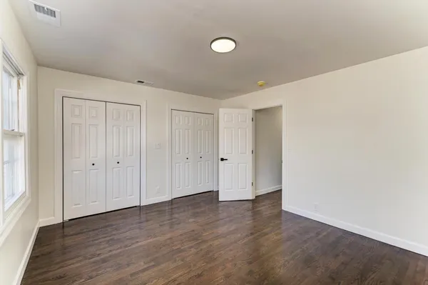 a view of an empty room with wooden floor