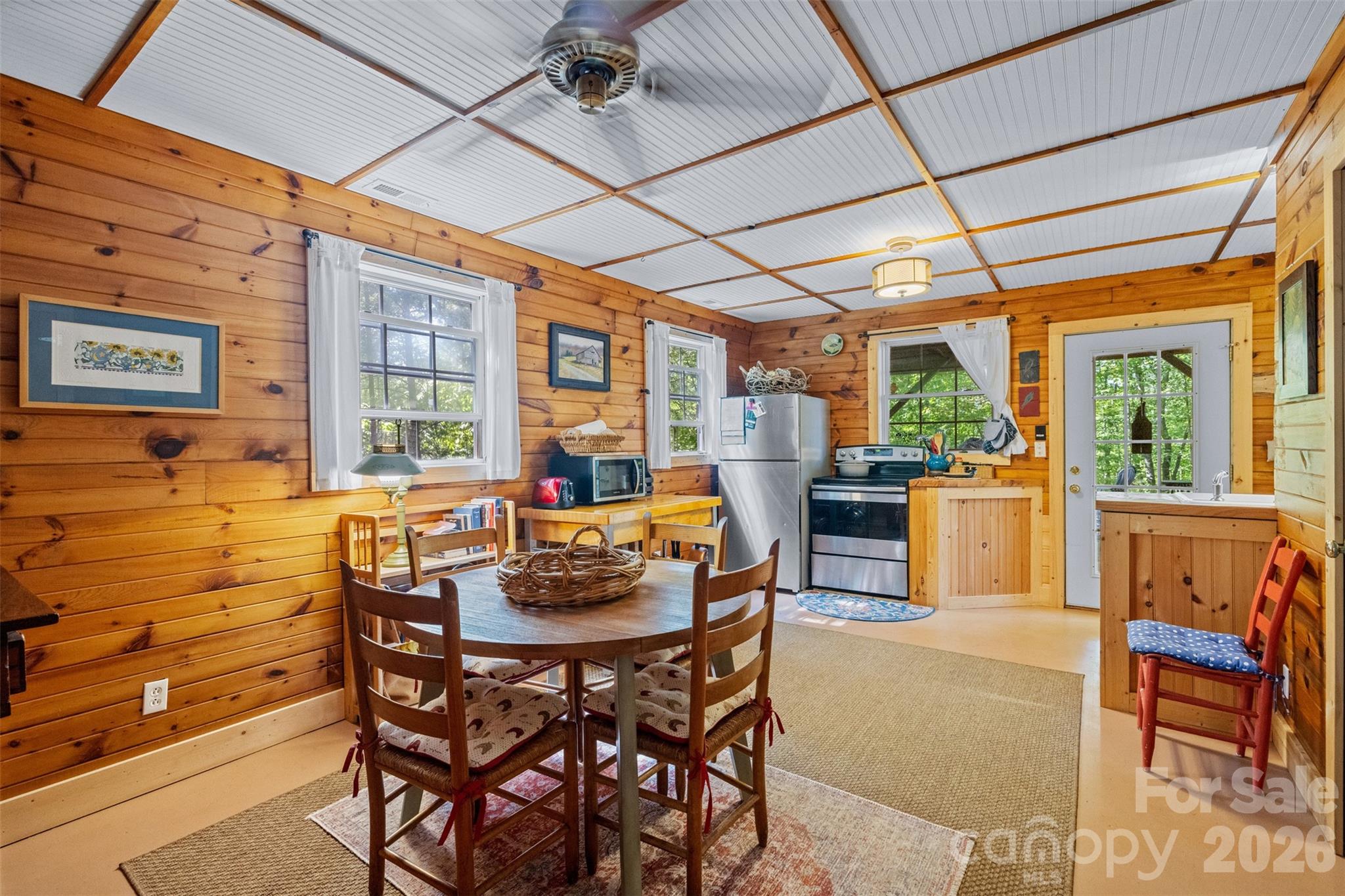 250 Burt Blackwell Road Mill Spring, NC 28756 - Photo 37 of 47 a dining room with furniture a floor to ceiling window and outdoor view