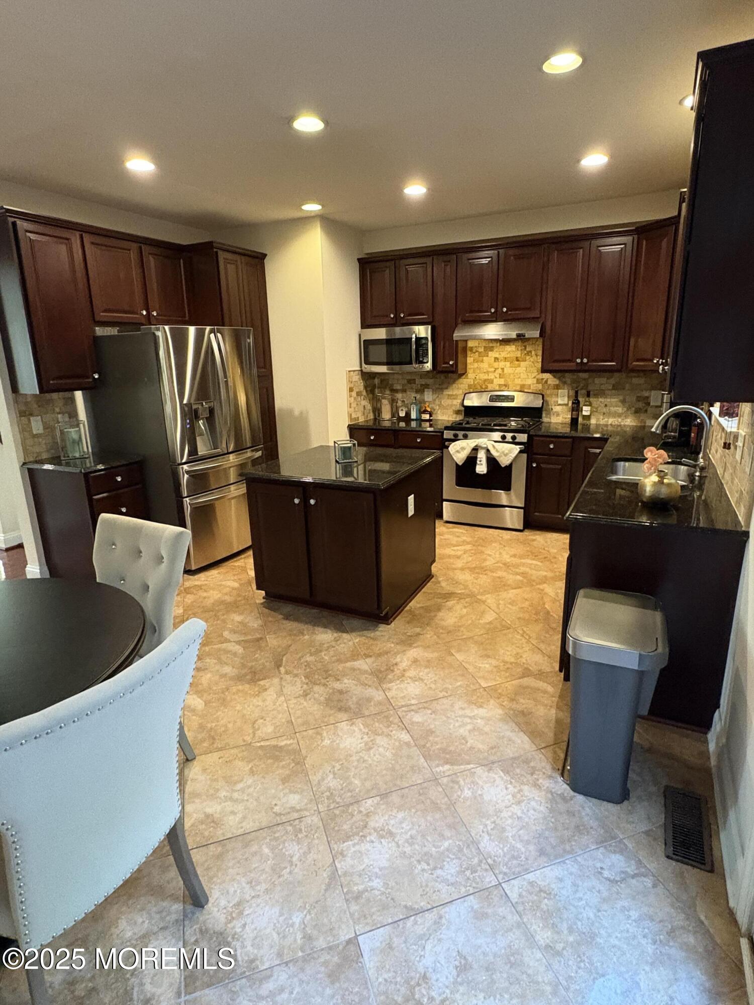 63 Pate Drive Middletown, NJ 07748 - Photo 7 of 50 a kitchen with stainless steel appliances granite countertop a refrigerator top oven a sink a stove and a granite counter top