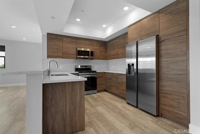 a kitchen with stainless steel appliances kitchen island granite countertop a refrigerator a sink and a stove