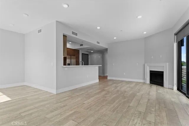 a view of a big room with wooden floor and fireplace