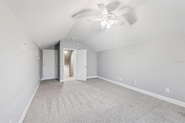 an empty room with a ceiling fan and window