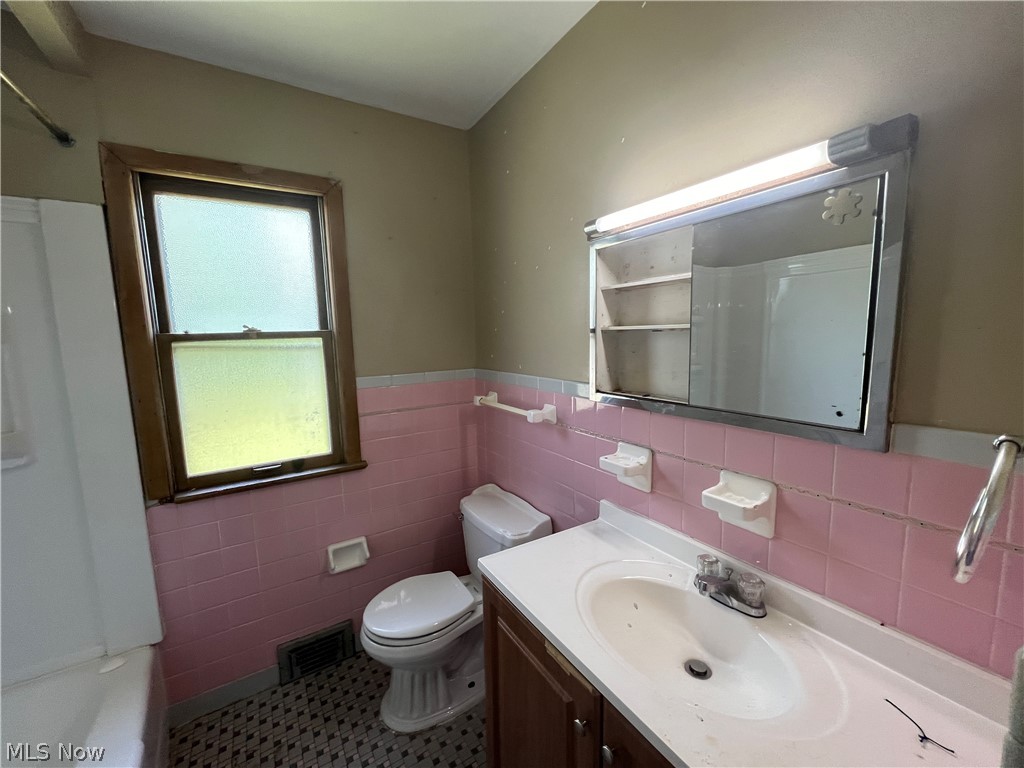 20731 Donnybrook Road Maple Heights, OH 44137 - Photo 9 of 17 Full bathroom with vanity, tile patterned floors, tasteful backsplash, tile walls, and toilet