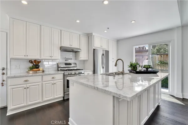 a kitchen with stainless steel appliances kitchen island granite countertop a stove a sink and a microwave
