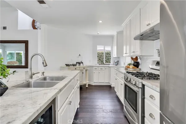 a kitchen with stainless steel appliances granite countertop a refrigerator sink and stove