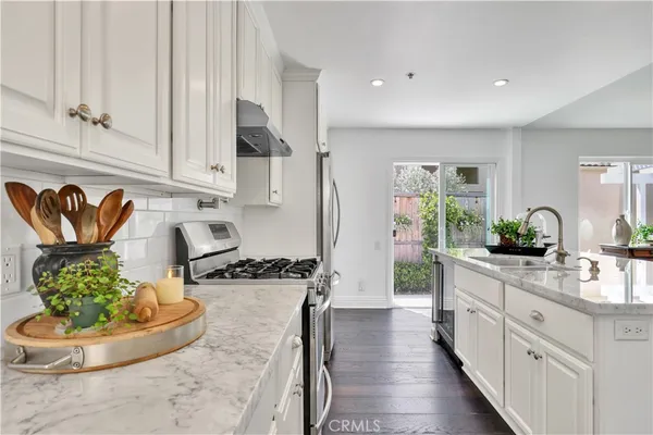 a kitchen with granite countertop a sink and a living room view