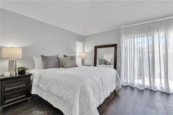 a bathroom with a granite countertop sink a toilet a large mirror a shower and vanity