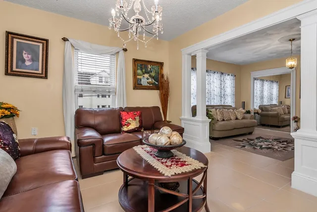 a living room with furniture a dining table and a chandelier