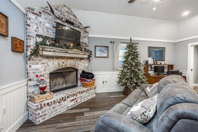 a living room with furniture a flat screen tv and a fireplace