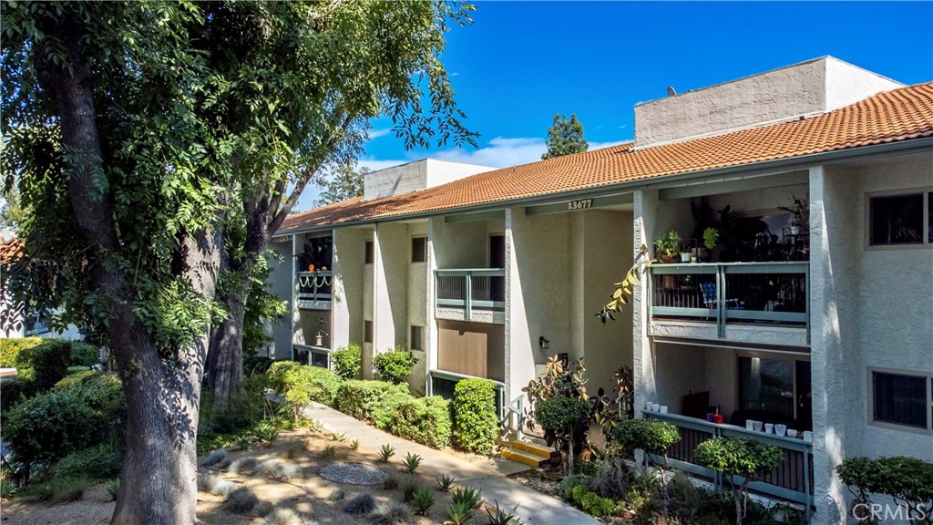 23677 Park Capri, Unit 20 Calabasas, CA 91302 - Photo 1 of 19 a view of a house with potted plants and a tree