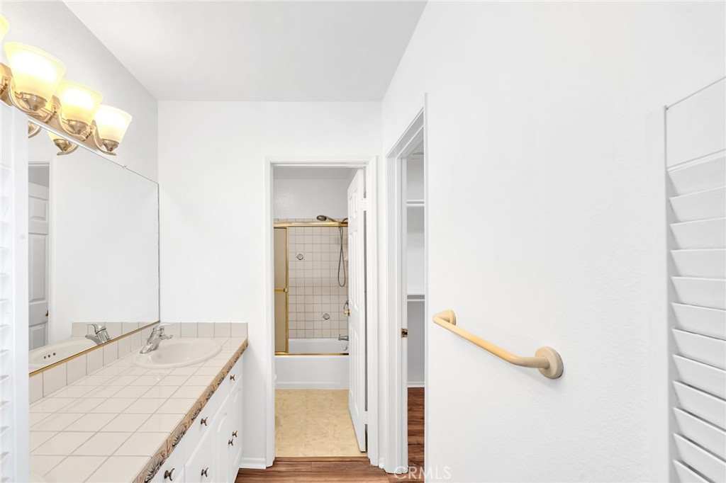 23677 Park Capri, Unit 20 Calabasas, CA 91302 - Photo 11 of 19 a bathroom with a granite countertop sink and mirror with bathtub