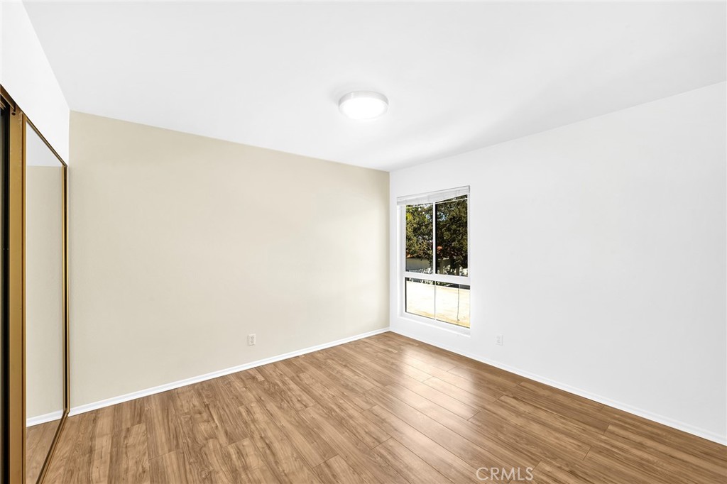23677 Park Capri, Unit 20 Calabasas, CA 91302 - Photo 14 of 19 an empty room with wooden floor and windows