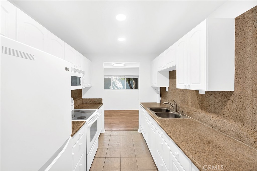 23677 Park Capri, Unit 20 Calabasas, CA 91302 - Photo 6 of 19 a kitchen with granite countertop a sink and cabinets
