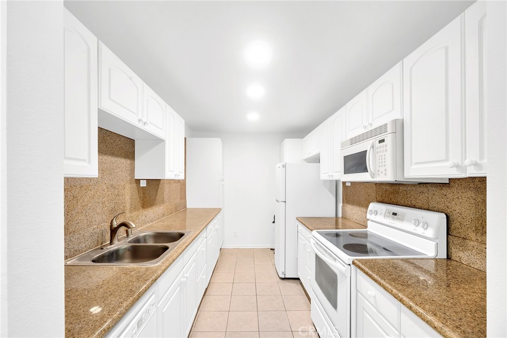 23677 Park Capri, Unit 20 Calabasas, CA 91302 - Photo 7 of 19 a kitchen with granite countertop a sink dishwasher stove and cabinets