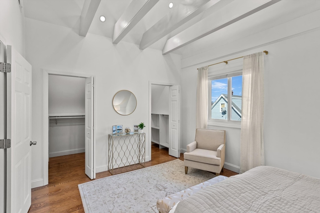 98 Flint Street, Unit 2 Somerville, MA 02145 - Photo 23 of 40 a bedroom with a bed and a chandelier