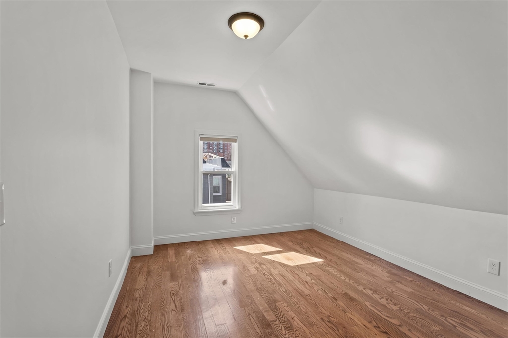98 Flint Street, Unit 2 Somerville, MA 02145 - Photo 27 of 40 an empty room with wooden floor and windows