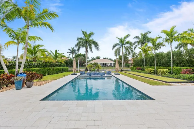 an aerial view of residential houses with outdoor space and lake view