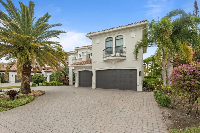 a view of a white house with a yard and potted plants