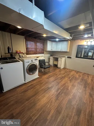 a kitchen with kitchen island granite countertop a sink cabinets and wooden floor