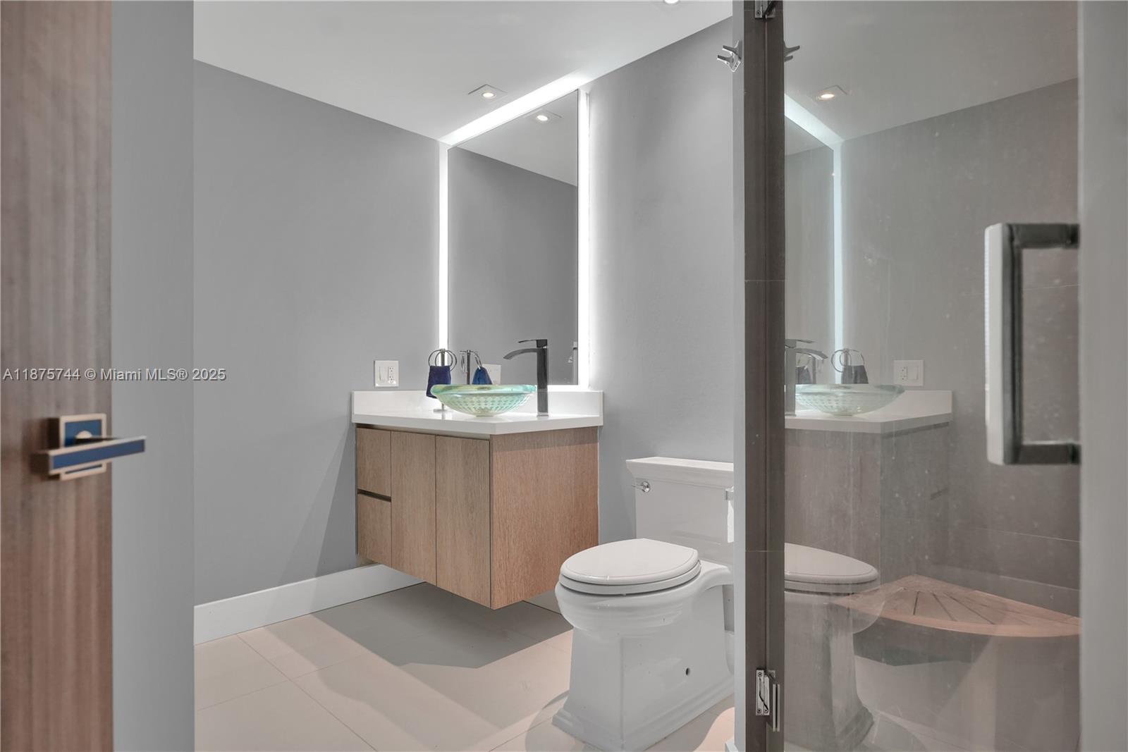 4779 Collins Avenue, Unit 1805 Miami Beach, FL 33140 - Photo 34 of 39 a bathroom with a toilet sink and a mirror