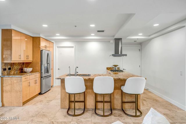 a kitchen with kitchen island a stove a table and chairs in it