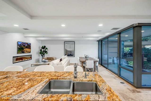 a living room with stainless steel appliances furniture a dining table and kitchen view