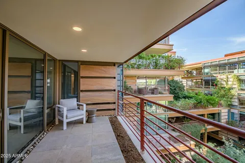 a balcony with a lot of plants in front of it