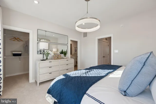 a bedroom with a large bed and a chandelier