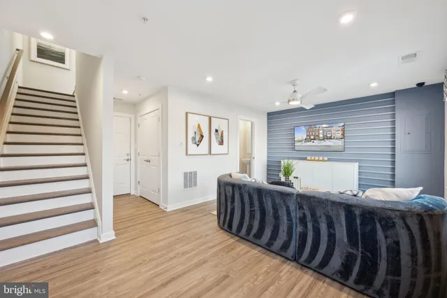 a living room with furniture and a wooden floor