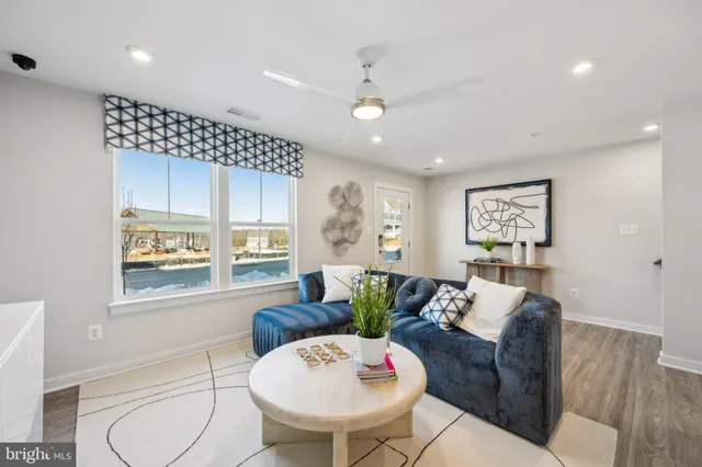 a living room with furniture a table and a large window