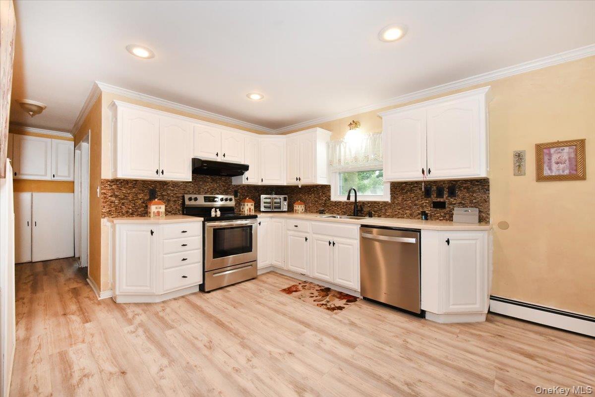 307 Blacksmith Road Levittown, NY 11756 - Photo 14 of 27 a kitchen with granite countertop white cabinets and white appliances