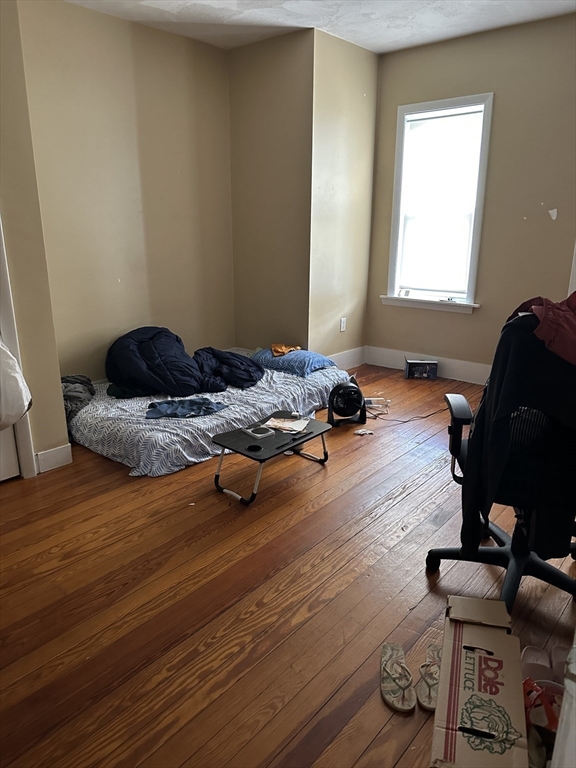 5 Lowden Avenue, Unit 2 Somerville, MA 02144 - Photo 14 of 20 a bedroom with a bed and wooden floor