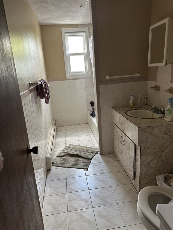 5 Lowden Avenue, Unit 2 Somerville, MA 02144 - Photo 17 of 20 a bathroom with a sink a toilet and mirror