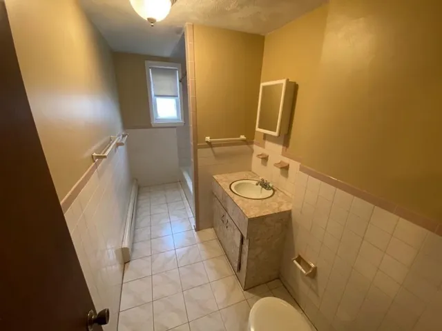 a bathroom with a sink mirror vanity and toilet