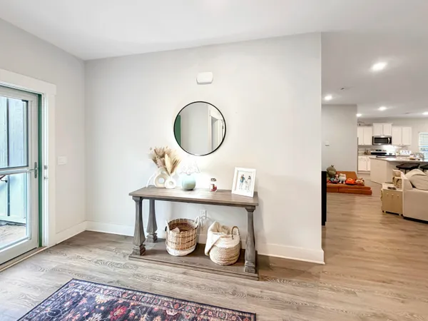 a living room with stainless steel appliances kitchen island furniture and a wooden floor